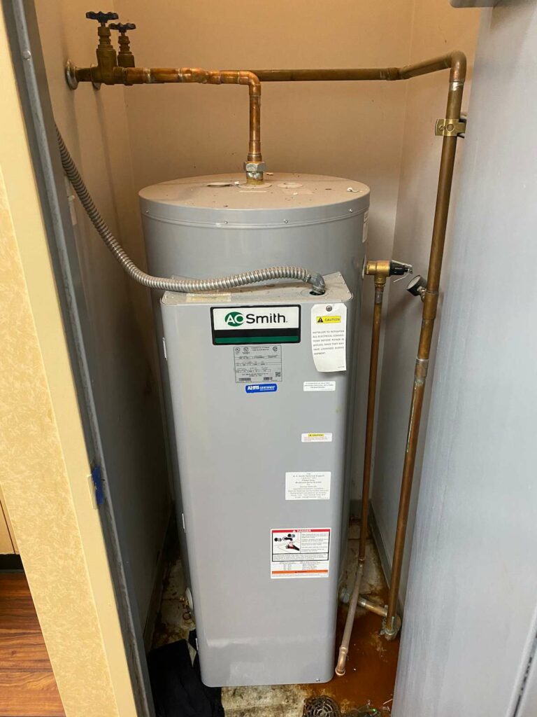 A New 50 gallon AO Smith gray water heater in a closet.
