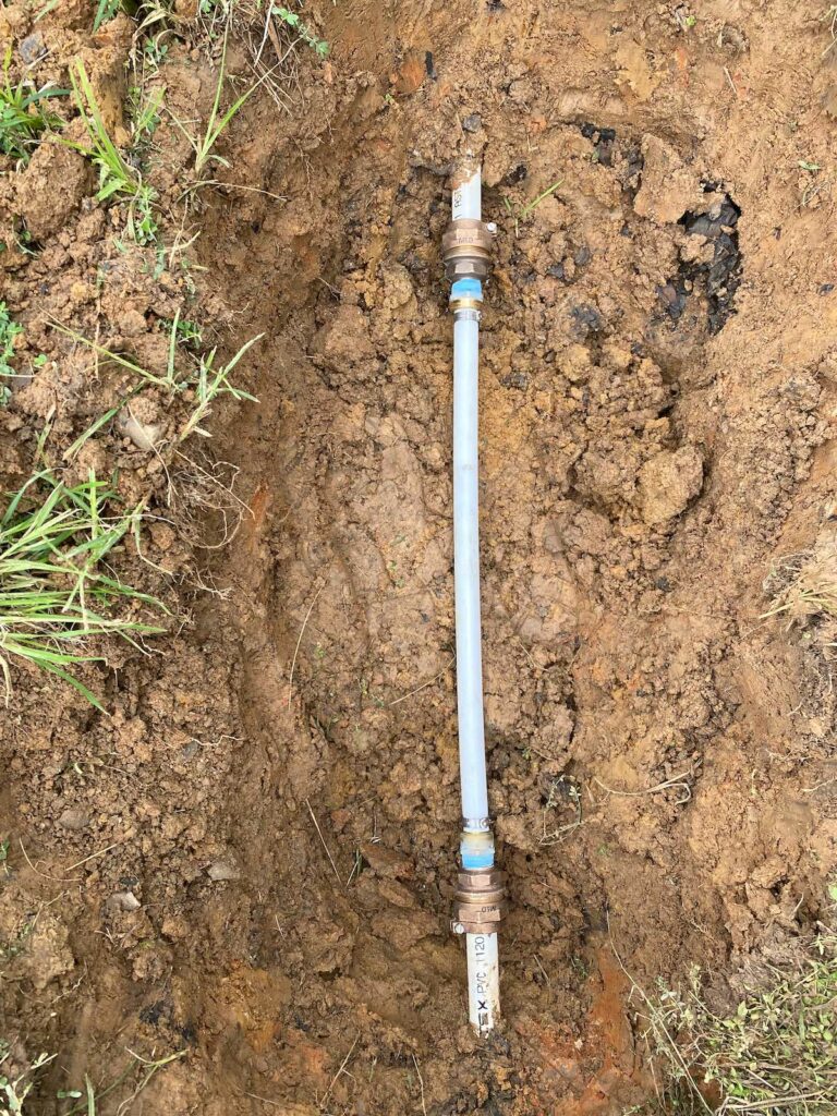 A newly repaired water line in a muddy hole.